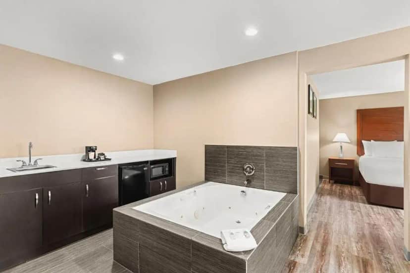 a large bathroom with a tub and a bed at Comfort Inn & Suites Beaverton - Portland West in Beaverton