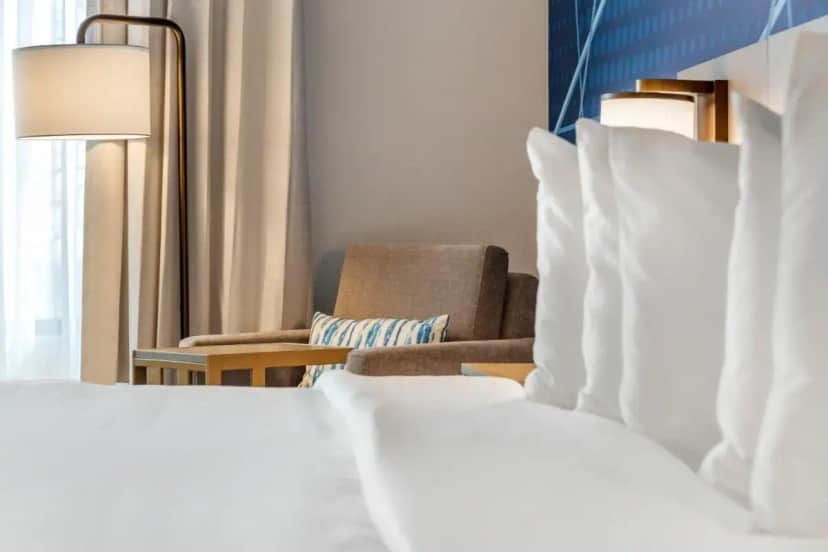 a hotel room with two beds and a chair at Comfort Inn & Suites Rapid City near Mt Rushmore in Rapid City