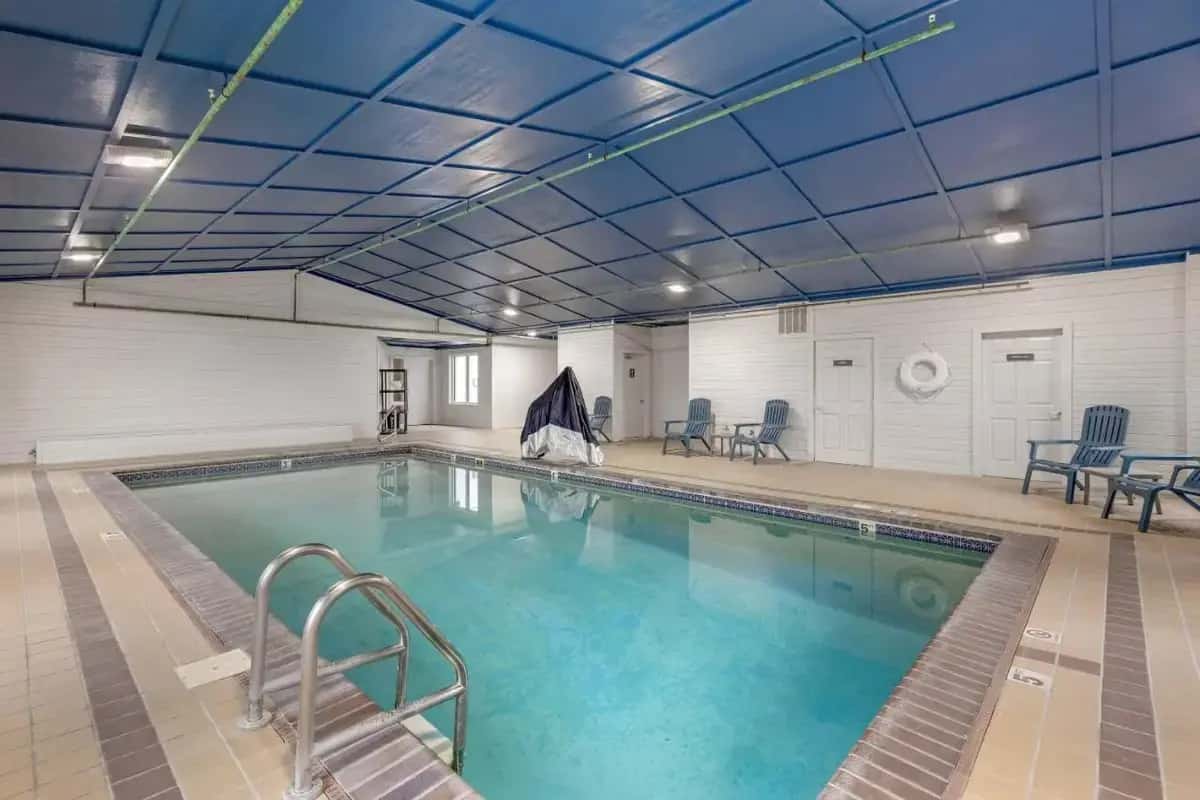 a large swimming pool with blue ceilings in a building at Comfort Inn & Suites Summerset - North Rapid City in Summerset
