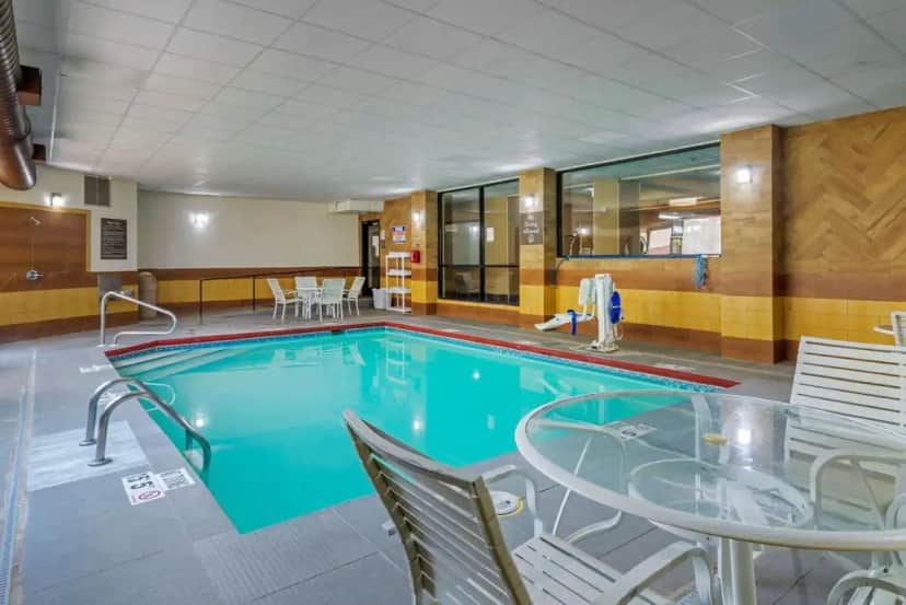 a large swimming pool with a table and chairs at Comfort Inn Columbus near Fort Benning in Columbus