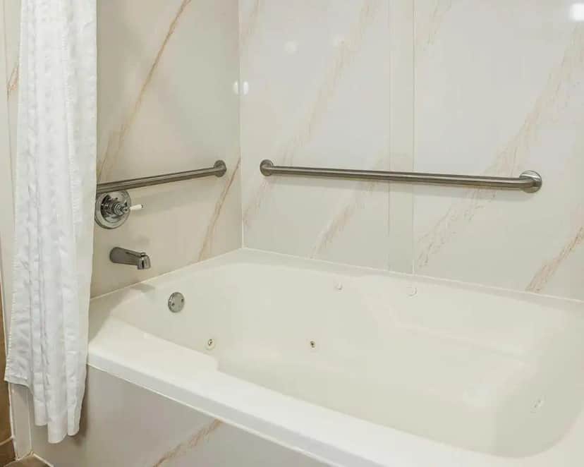 a white bath tub in a bathroom with a shower curtain at Comfort Inn Edinburgh - Columbus in Edinburgh