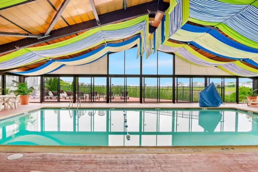 a pool with colorful umbrellas in a building at Comfort Inn Gold Coast in Ocean City