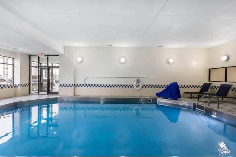 a swimming pool with blue water in a building at Comfort Inn SW Omaha I-80 in Omaha