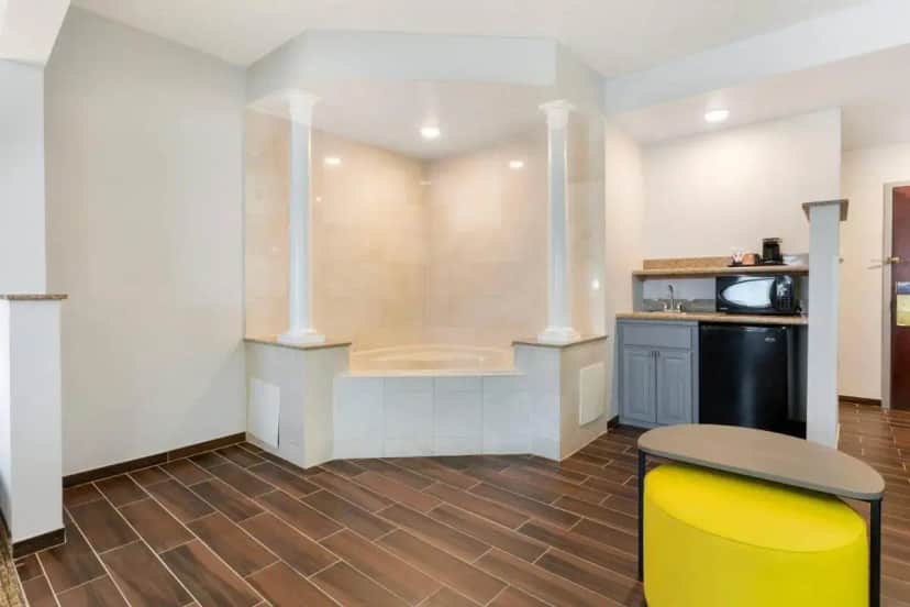 a kitchen with a yellow stool and a microwave at Comfort Suites East Brunswick - South River in East Brunswick