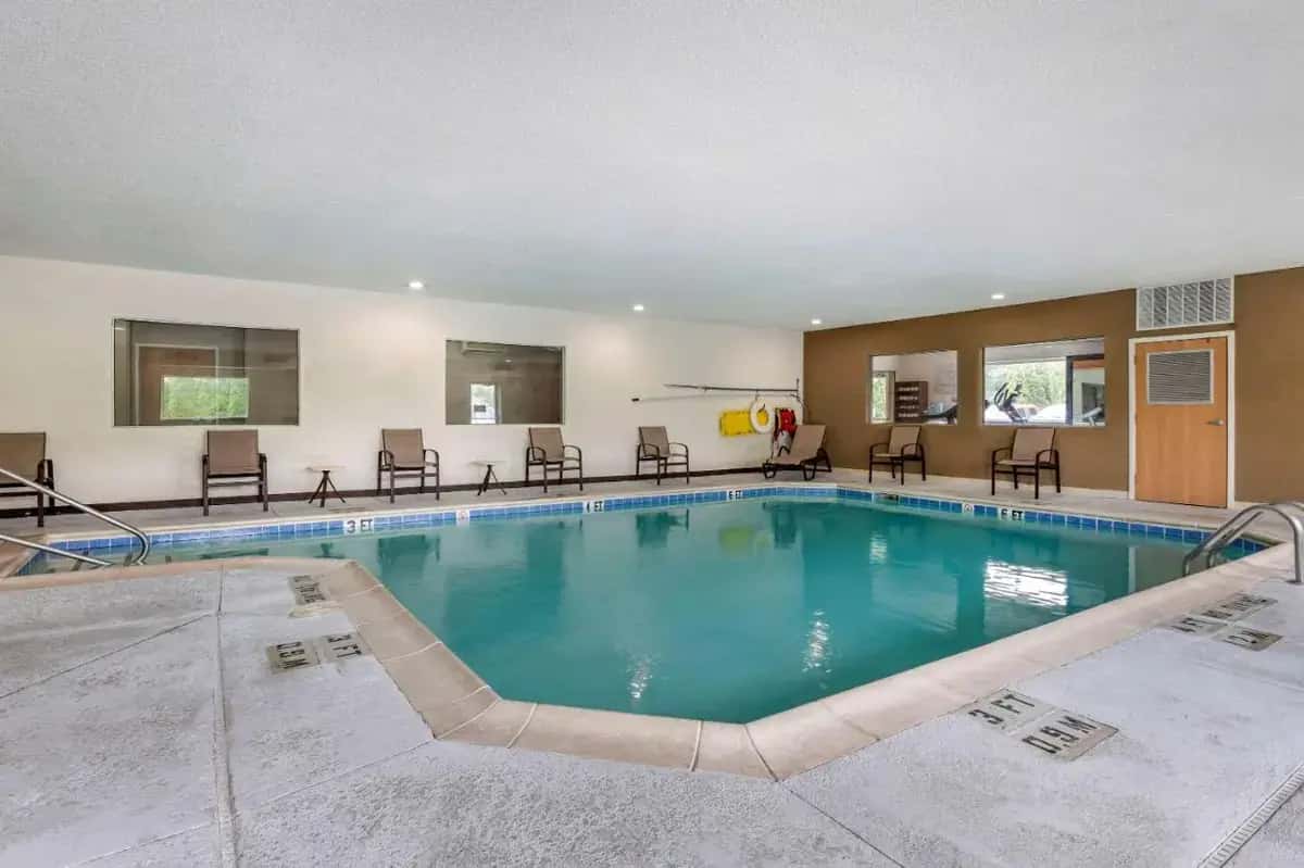 a large swimming pool with chairs and tables at Comfort Suites Elkhart North in Elkhart
