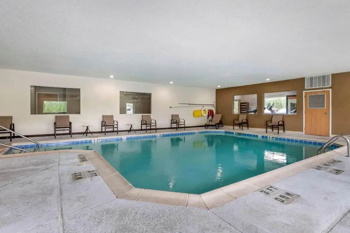 a large swimming pool with chairs and tables at Comfort Suites Elkhart North in Elkhart