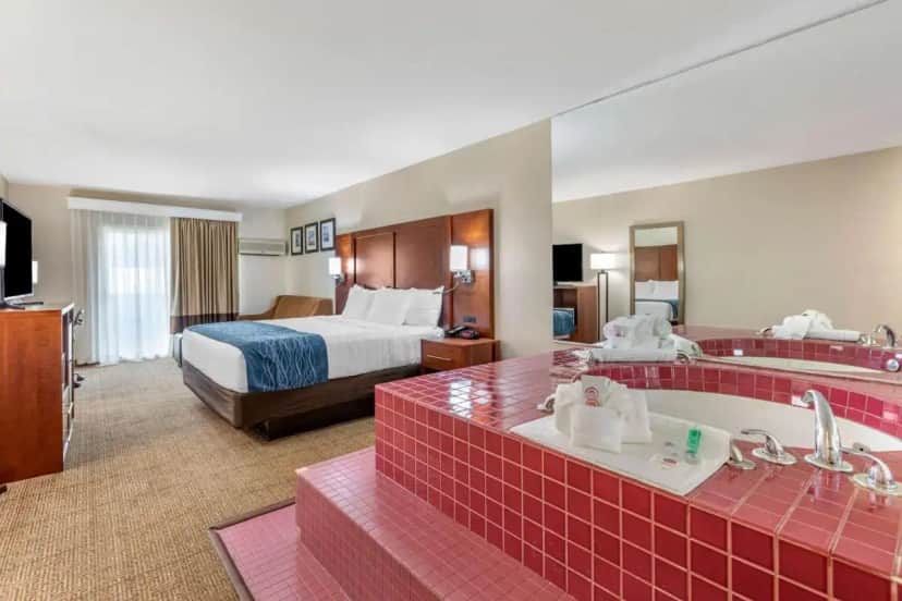 a hotel room with a bed and a bath tub and a room at Continental Inn San Diego Hotel Escondido in Escondido
