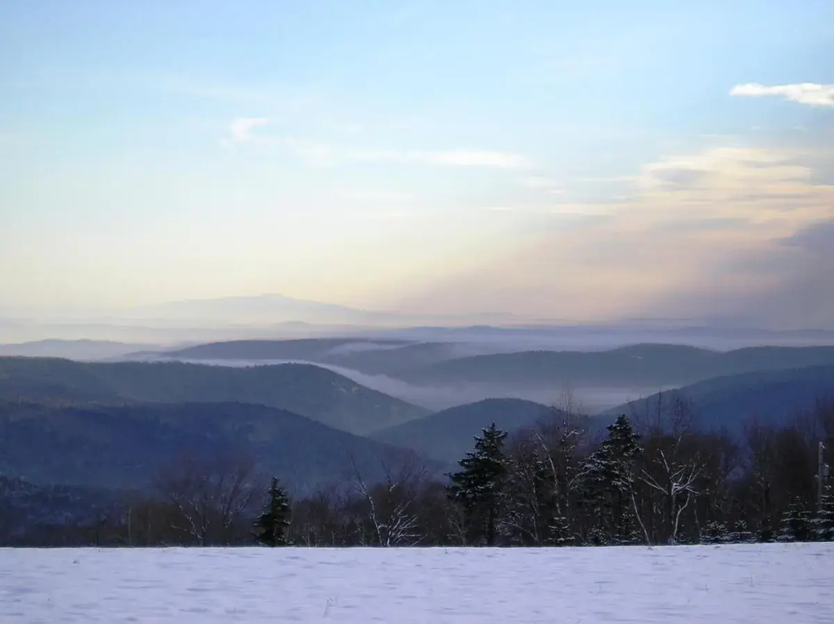 a view of a snowy mountain with trees and mountains at Cooper Hill Inn in West Dover