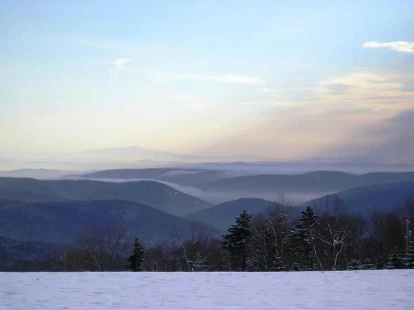 a view of a snowy mountain with trees and mountains at Cooper Hill Inn in West Dover
