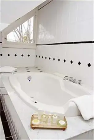 a bathroom with a white tub and a sink at Copper Beech Inn in Ivoryton