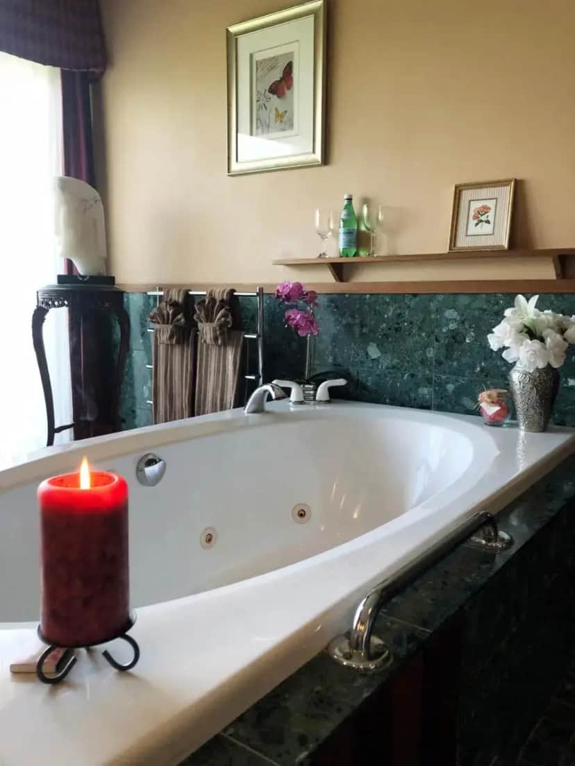 a bathroom with a white bath tub with a candle at Coppertoppe Inn & Retreat Center in Hebron