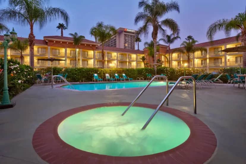 a hotel with a swimming pool and a resort at Cortona Inn and Suites Anaheim Resort in Anaheim