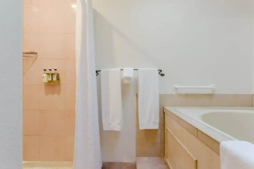 a bathroom with white towels and a tub and a sink at Cottage Grove Inn in Calistoga