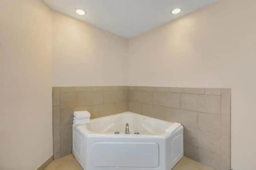 a white bath tub in a bathroom with tiles at Country Inn & Suites by Radisson, Elk Grove Village-Itasca in Elk Grove Village