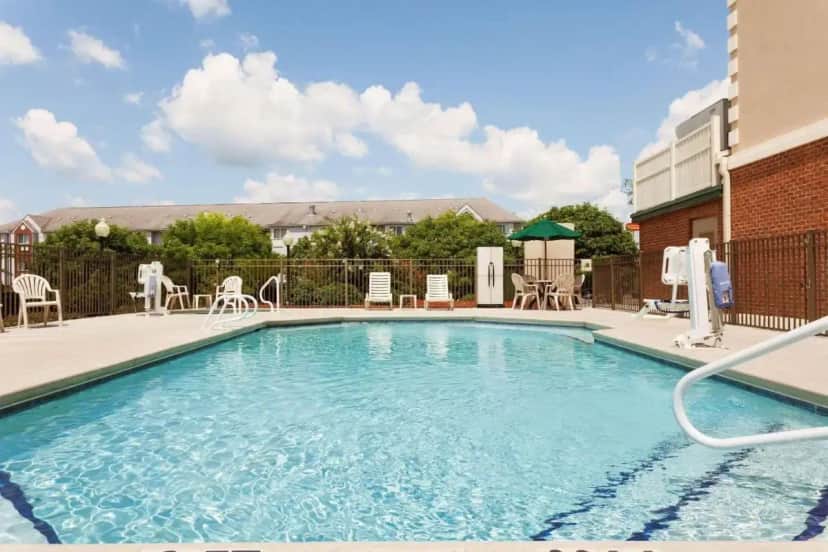 a swimming pool with chairs and a table and chairs at Country Inn & Suites by Radisson, Tifton, GA in Tifton