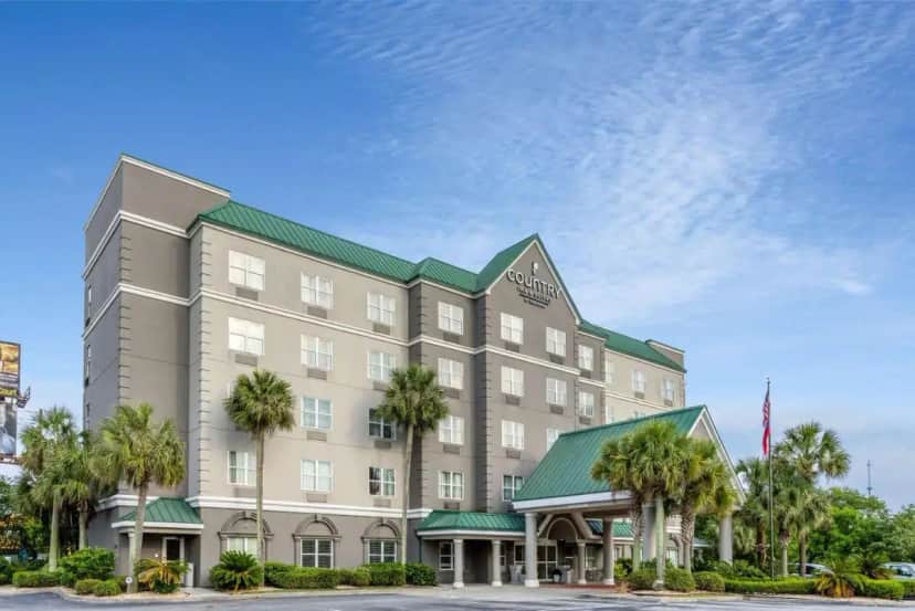 a rendering of a hotel with palm trees in front at Country Inn & Suites by Radisson, Valdosta, GA in Valdosta