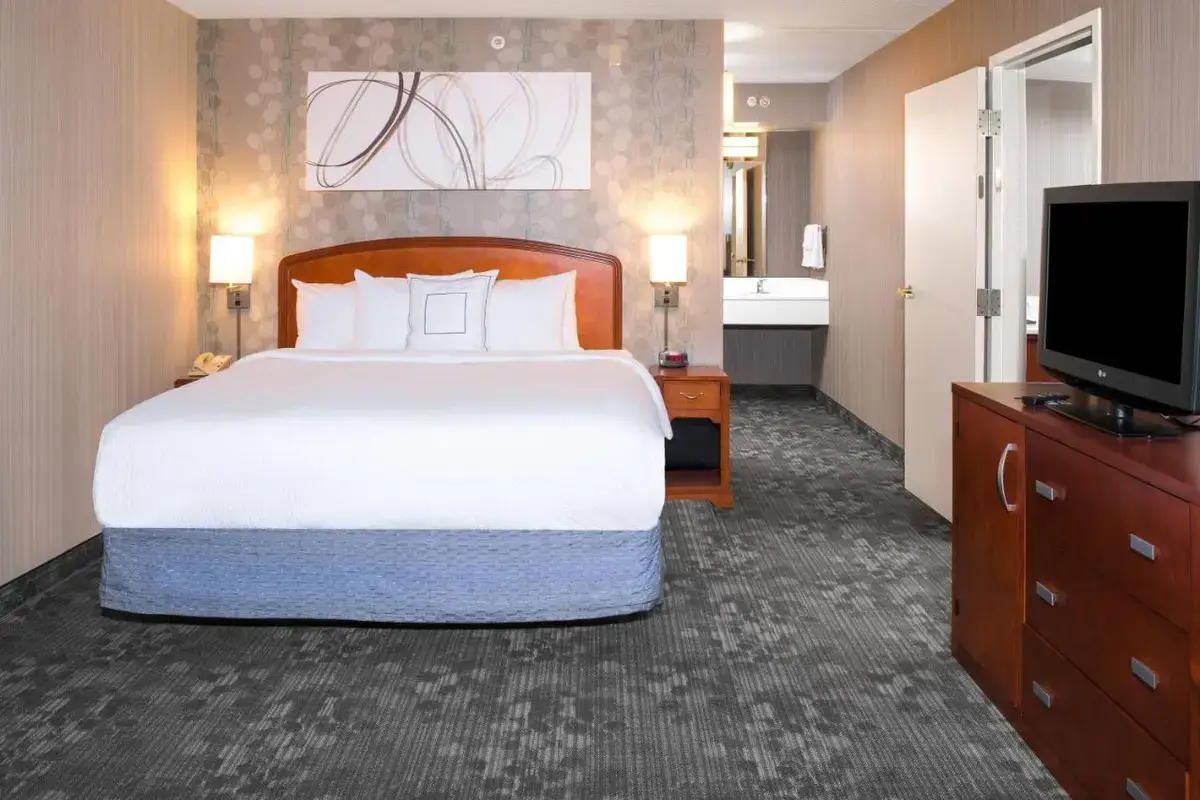 a hotel room with a large bed and a television at Courtyard by Marriott Charlotte Gastonia in Gastonia