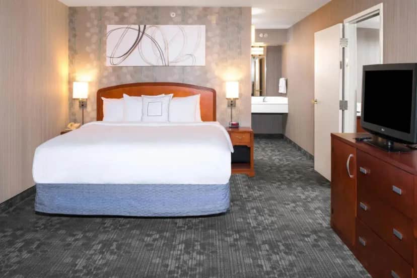 a hotel room with a large bed and a television at Courtyard by Marriott Charlotte Gastonia in Gastonia
