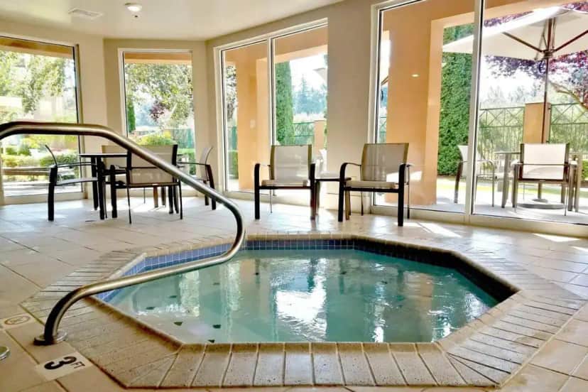 a hot tub in a room with a table and chairs at Courtyard Seattle North / Lynnwood Everett in Lynnwood
