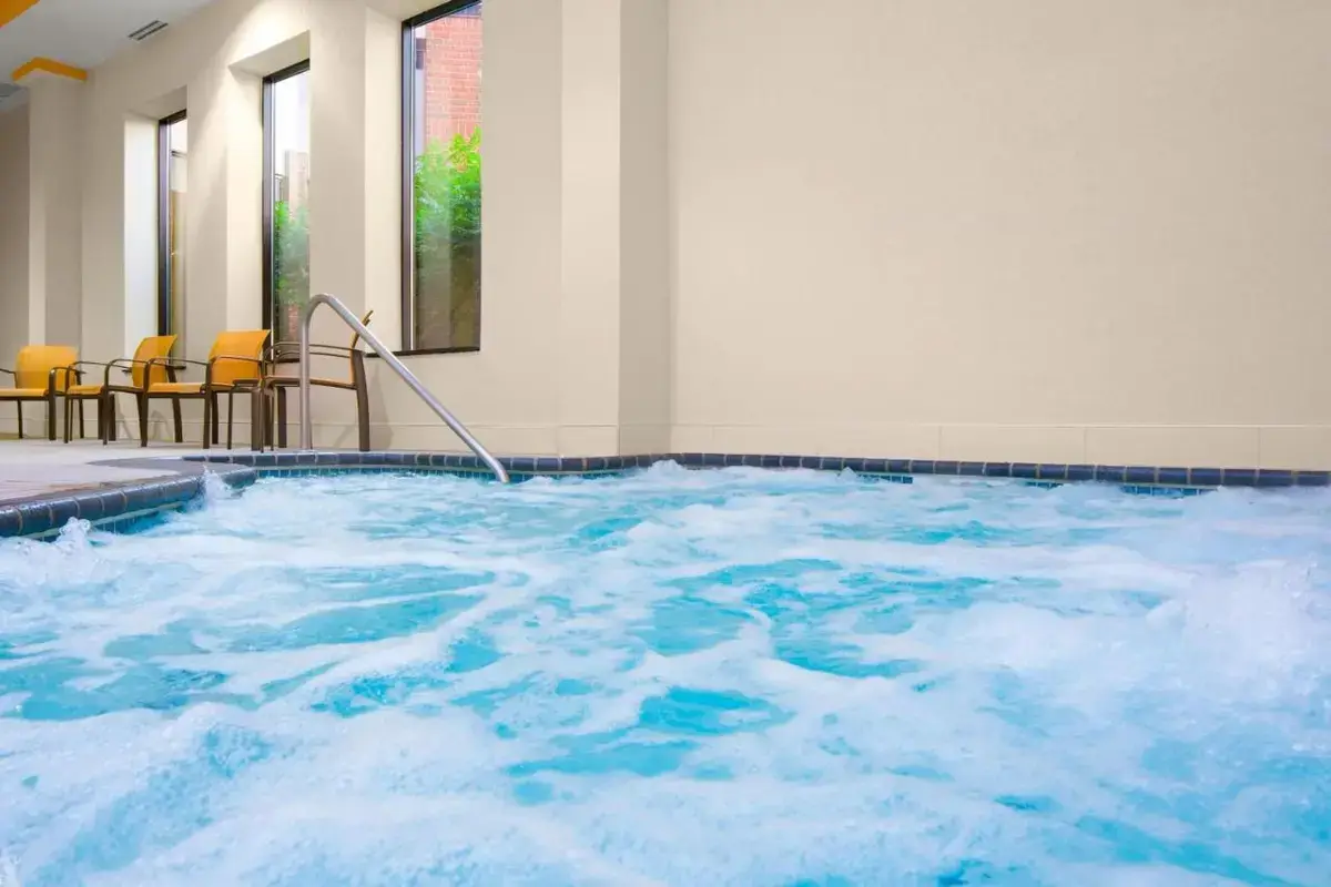 a hot tub with blue water in a room at Courtyard by Marriott St. Cloud in Saint Cloud