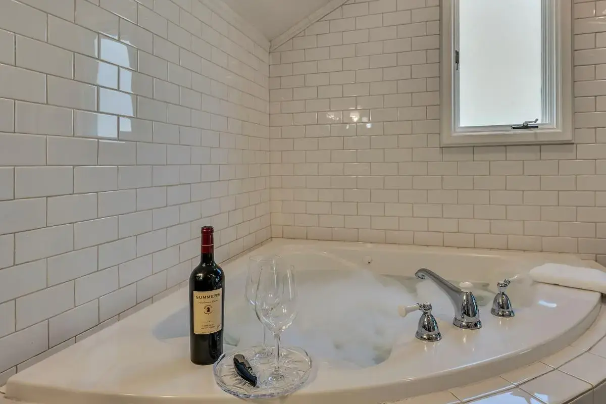 a bottle of wine and a wine glass in a bath tub at Craftsman Inn in Calistoga