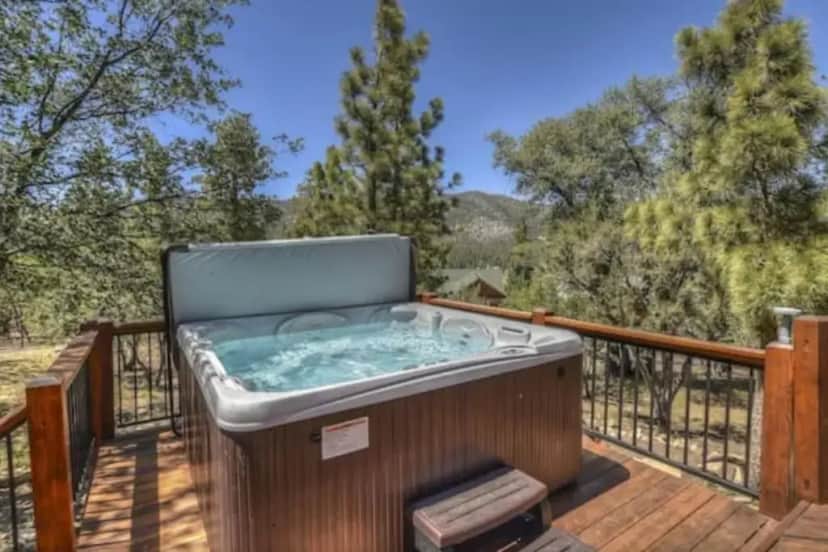 a hot tub on the deck of a house at CUSTOM SINGLE STORY CABIN WITH JACUZZI POOL TABLE & BIG GAME ROOM WITH ARCADE games in Big Bear Lake