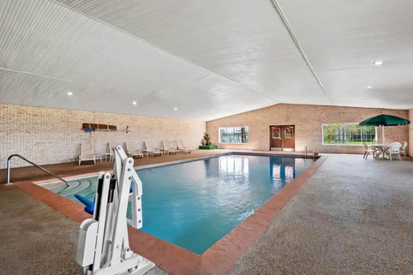 a swimming pool in a large building with a pool at Days Inn by Wyndham Whitmore Lake Near Ann Arbor And Brighton in Whitmore Lake