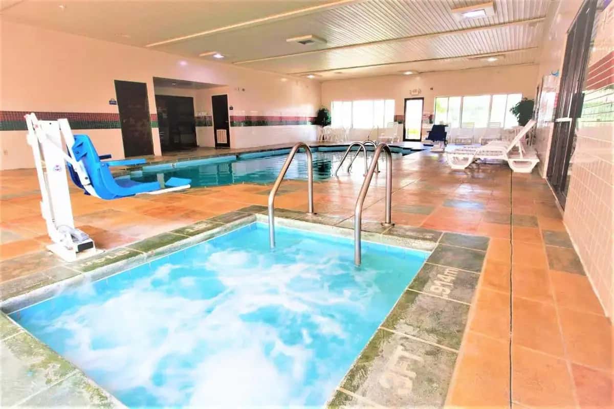 a large pool with a hot tub in a building at Days Inn by Wyndham Milan Sandusky South in Milan