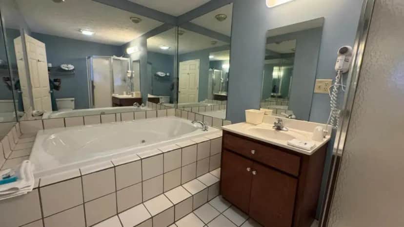 a bathroom with a tub and a sink and a mirror at Deerfield Inn & Suites Gadsden Near Attalla I 59 in Southside