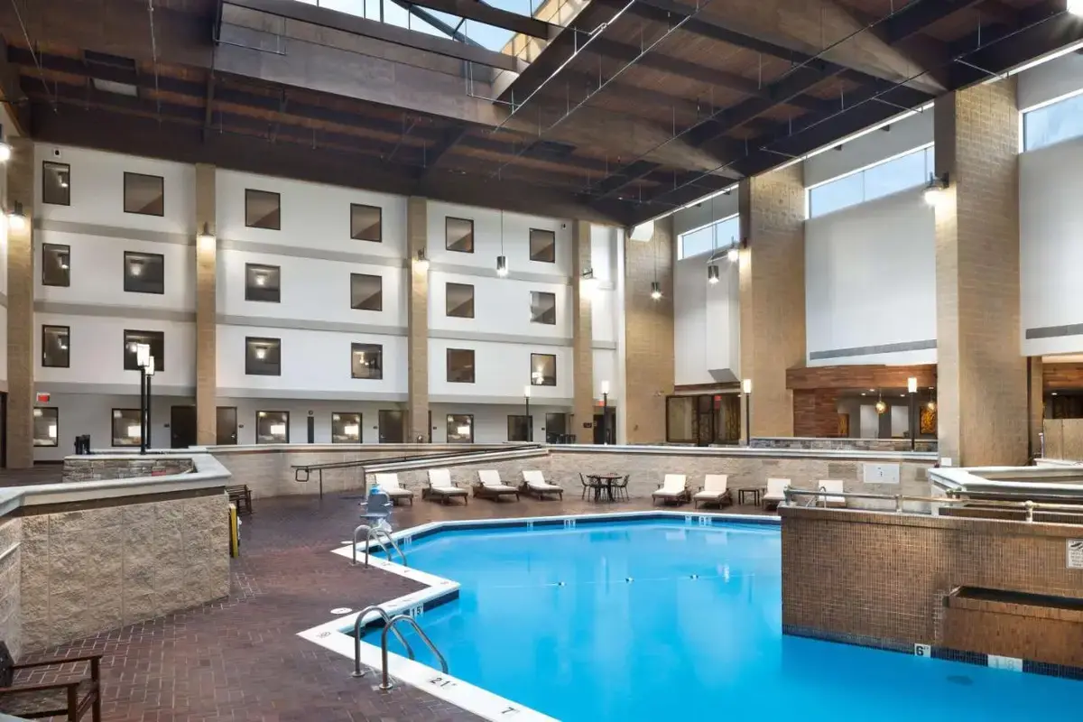 a large pool in a hotel lobby with chairs and a hotel at DoubleTree by Hilton Lawrence in Lawrence