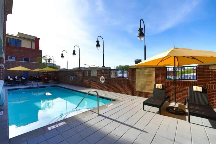 a swimming pool with two chairs and an umbrella at Hilton Garden Inn Savannah Historic District in Savannah