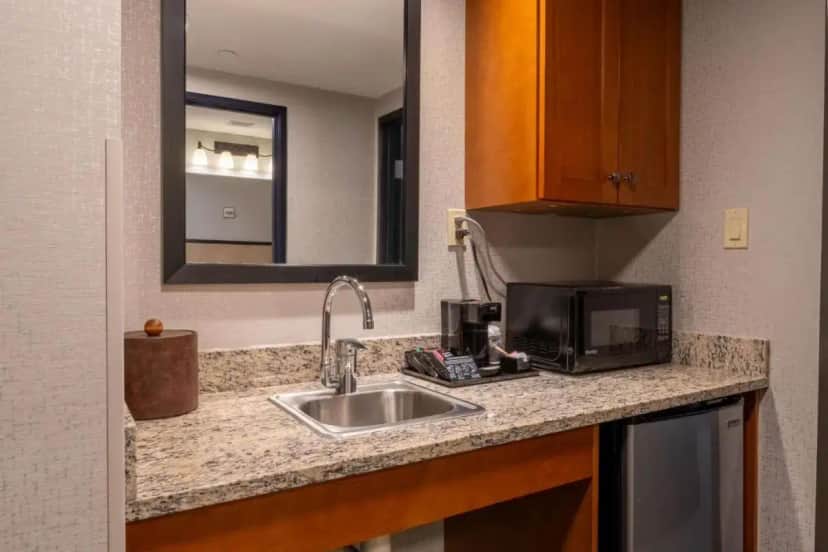 a kitchen counter with a sink and a microwave at Drury Plaza Hotel Broadview Wichita in Wichita