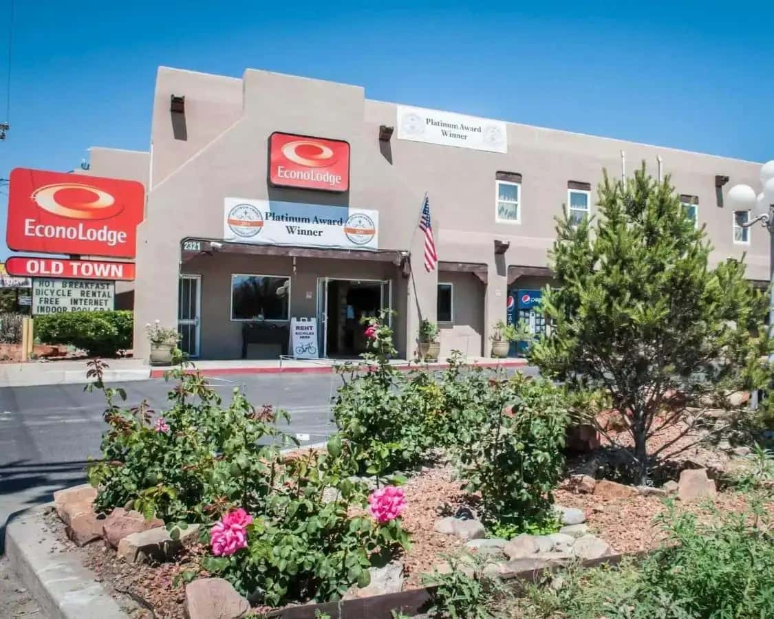 a front view of a building with flowers in front at Econo Lodge Albuquerque Old Town in Albuquerque