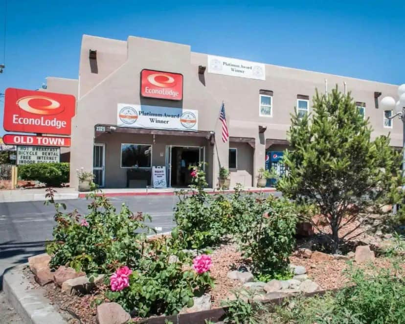 a front view of a building with flowers in front at Econo Lodge Albuquerque Old Town in Albuquerque