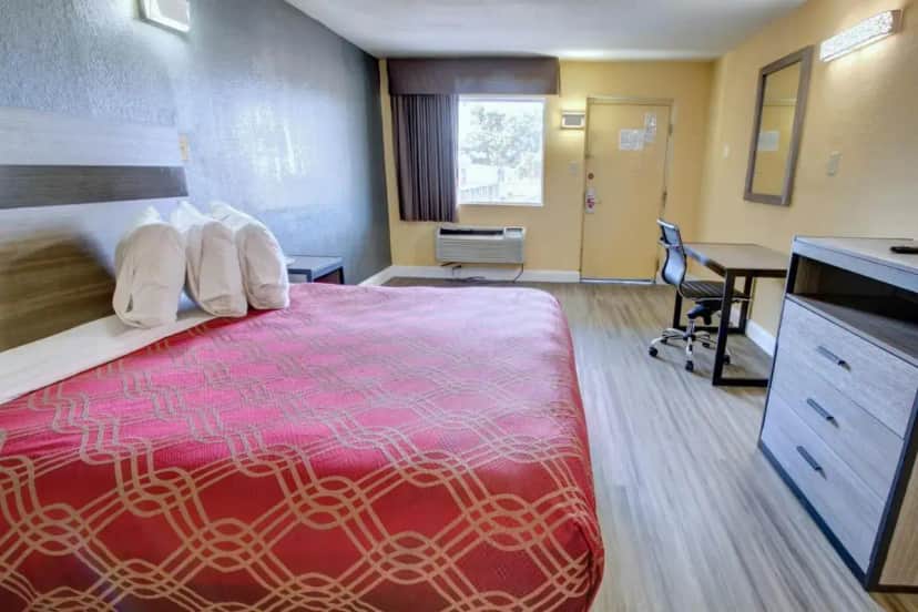 a hotel room with a large bed and a desk at Econo Lodge at Military Circle in Norfolk