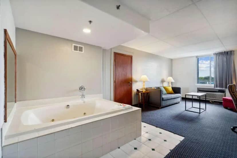 a large bathroom with a tub and a living room at Econo Lodge Inn & Suites Waterloo Downtown in Waterloo