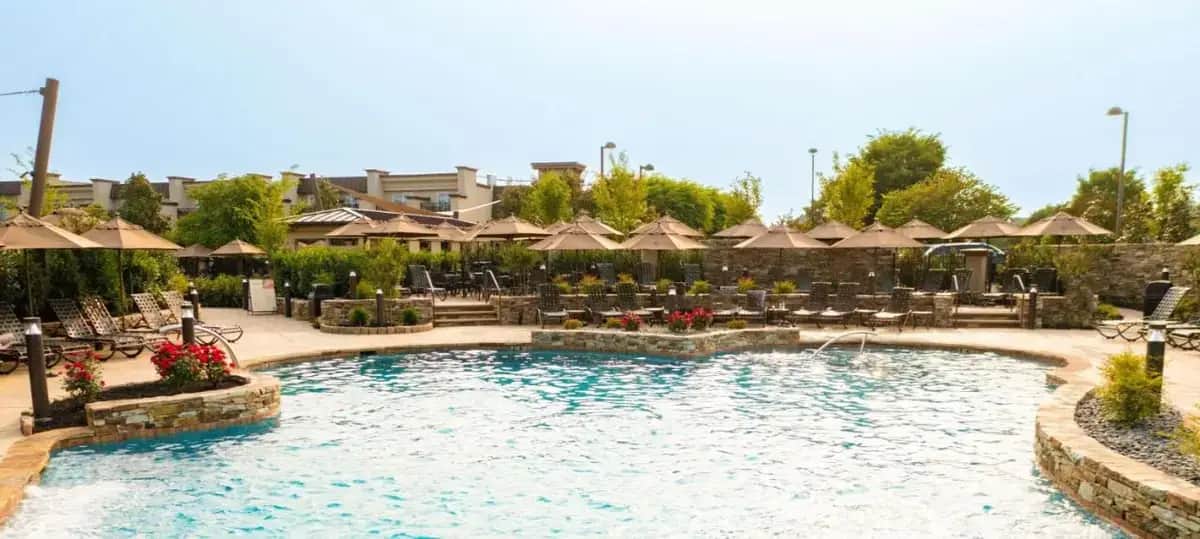 a large swimming pool with chairs and umbrellas at Eden Resort and Suites, BW Premier Collection in Lancaster
