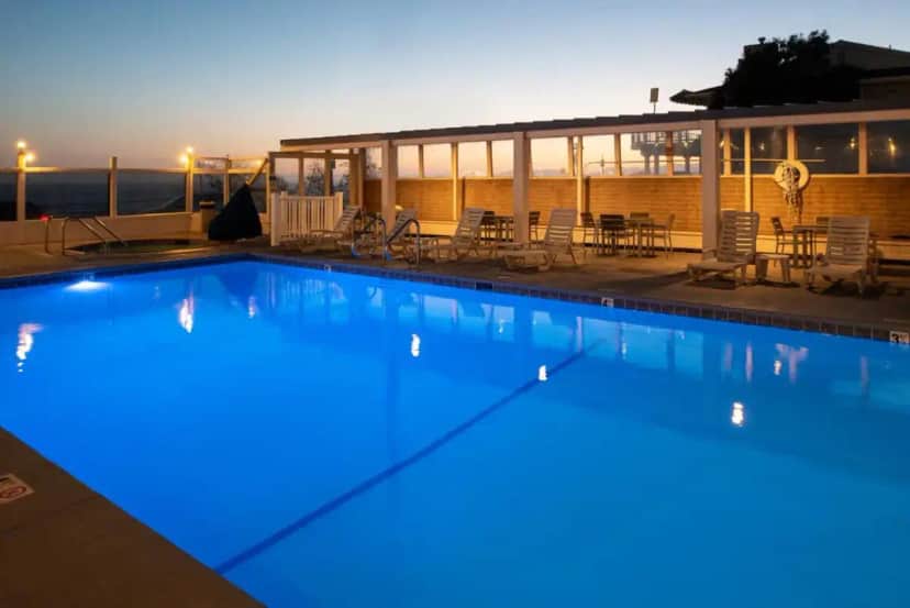 a large swimming pool with blue lighting on a building at Edgewater Inn and Suites in Pismo Beach