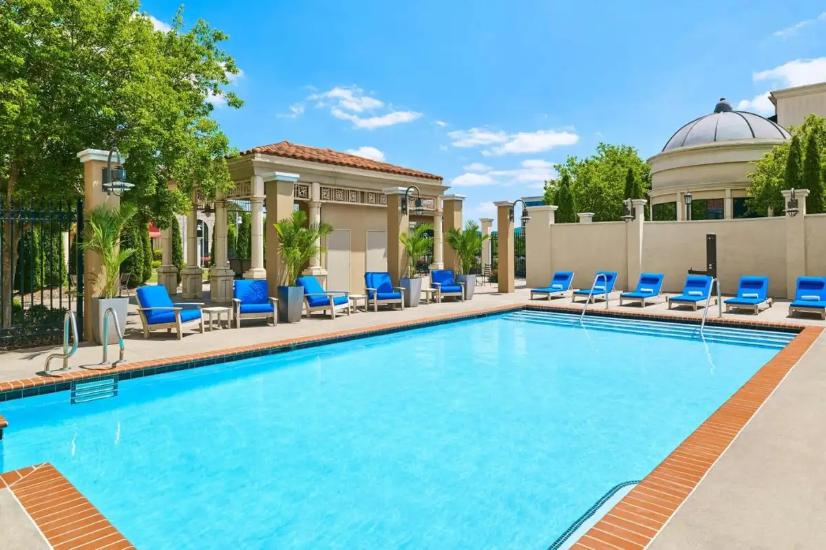 a swimming pool with blue chairs and a building at Element by Marriott Huntsville in Huntsville