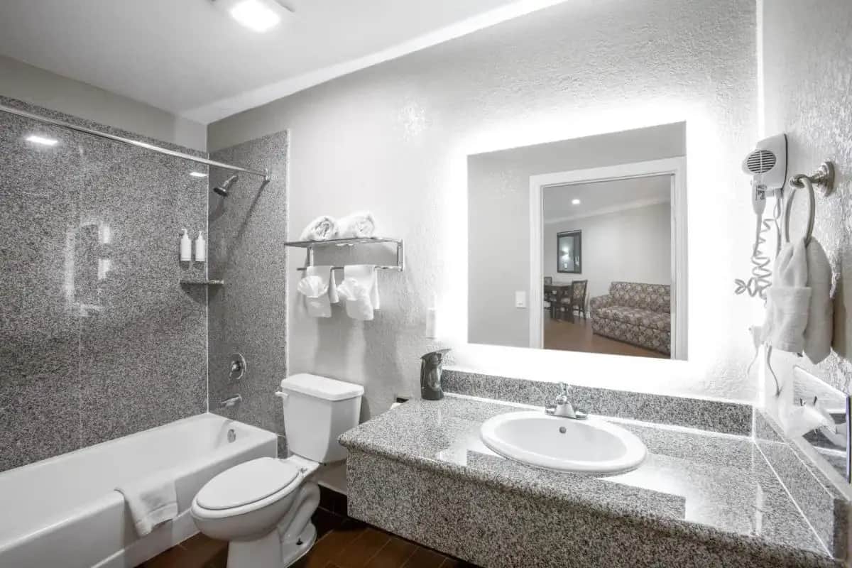 a bathroom with a sink and a toilet and a tub at Elev8 Hotel Los Angeles, LAX in Inglewood