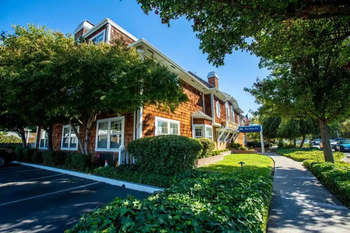 a brick house with trees in front of a street at Elm House Inn in Napa