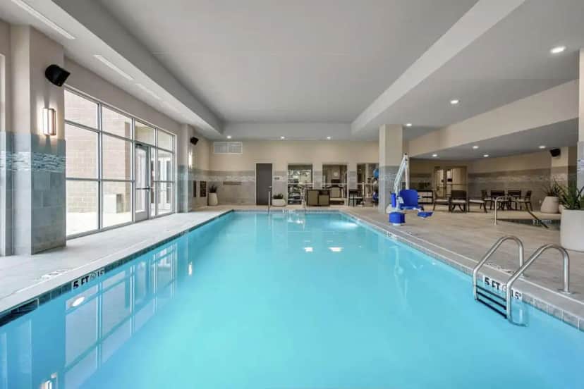 a large pool with blue water in a hotel room at Embassy Suites by Hilton Jonesboro Red Wolf Convention Center in Jonesboro