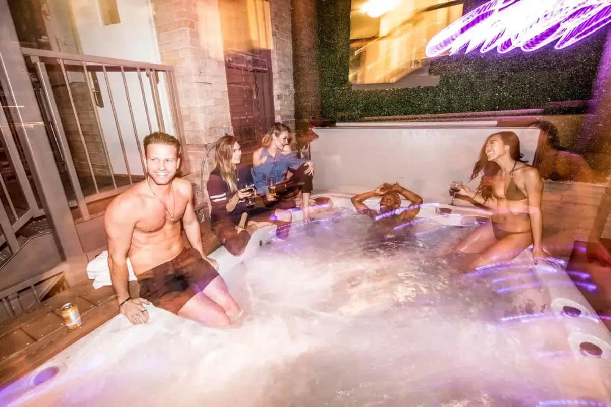 a group of people sitting in a hot tub at Ember Hostel in Denver