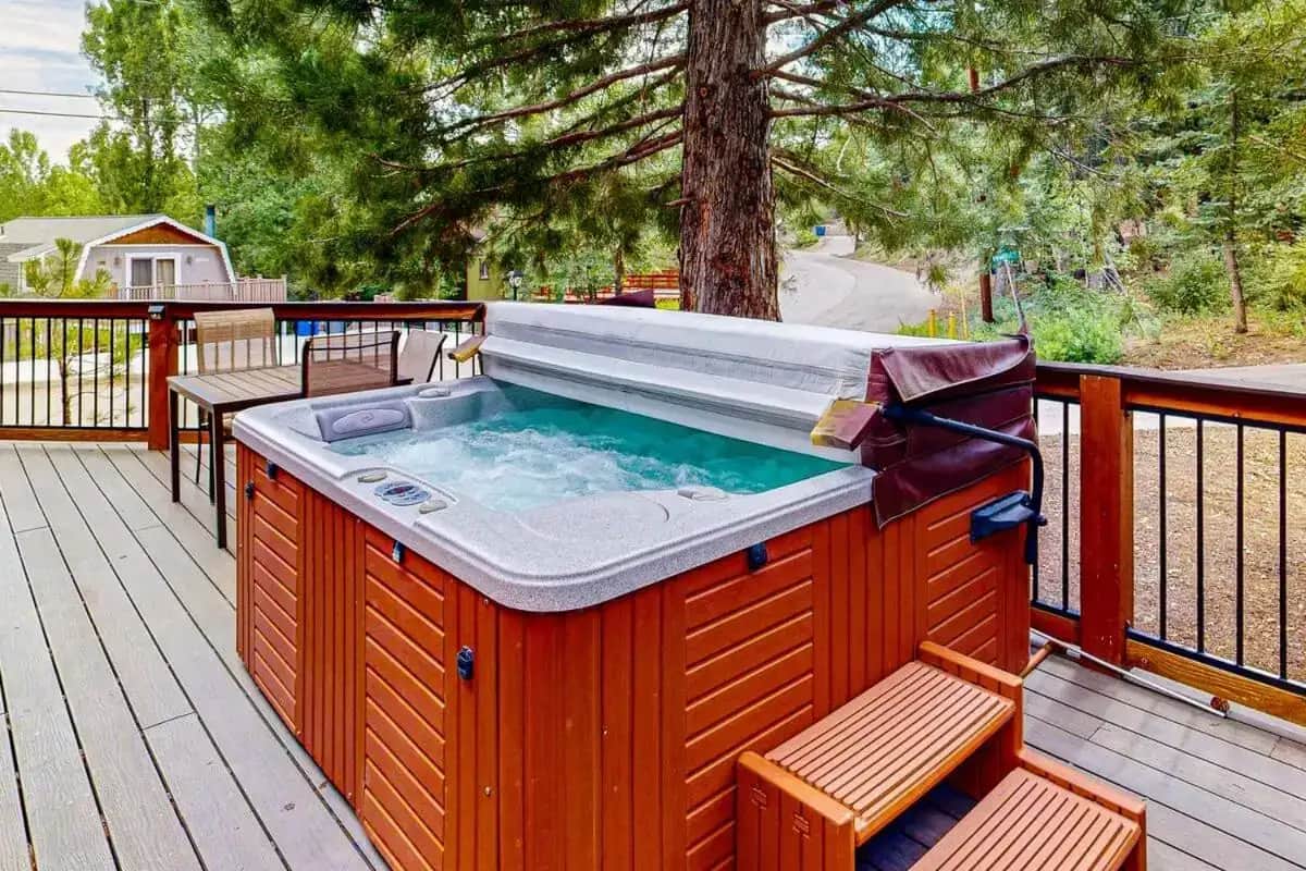a hot tub on a deck with two benches at Primrose Cabin ~ Mountain Cabin w/ hot tub, deck, fireplace & washer/dryer in Big Bear Lake