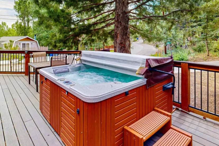 a hot tub on a deck with two benches at Primrose Cabin ~ Mountain Cabin w/ hot tub, deck, fireplace & washer/dryer in Big Bear Lake