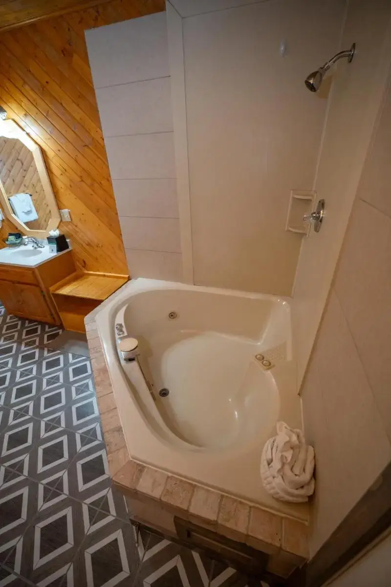 a bath tub in a bathroom with a sink at Estes Mountain Inn in Estes Park