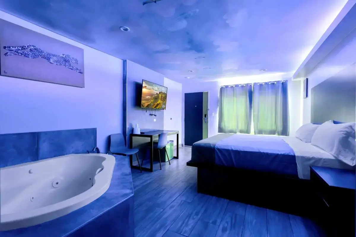 a hotel room with a bed and a bath tub at Exclusivo Inn and Suites in Lakewood