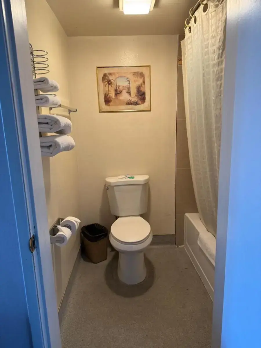a bathroom with a toilet and a shower and a tub at Fiesta Inn Los Angeles - Bell Gardens in Bell Gardens