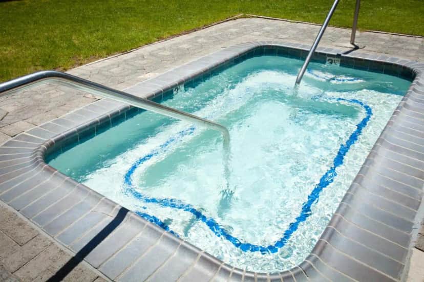 a hot tub with blue water in a backyard at Forest Suites Resort at the Heavenly Village in South Lake Tahoe