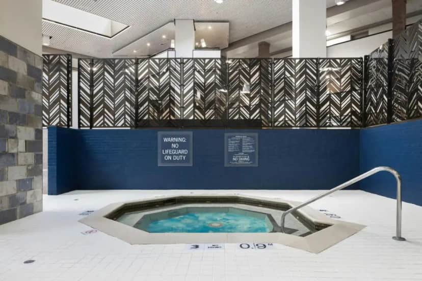 a hot tub in a room with blue walls at Four Points by Sheraton Detroit Novi in Novi